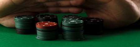 A businessman at a green gaming table pushes the casino chips away from him. Losing money.の写真素材