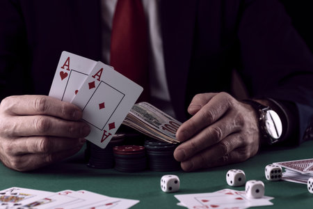 Businessman at green playing table with gambling chips and cards playing poker and blackjack in...