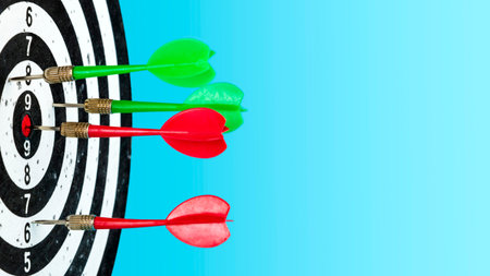 Aim with the arrow in the center. Target with red and green darts in the center on a light blue...