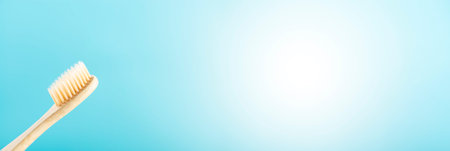 Environmentally friendly natural bamboo toothbrush on blue background. Health care, copy space.