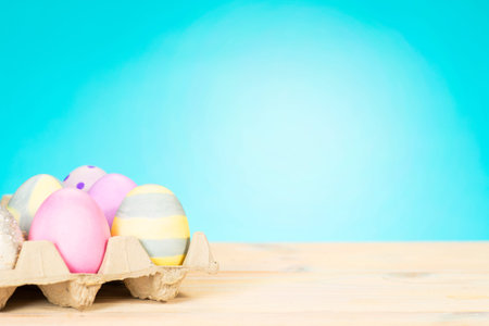Colorful easter eggs on a stand on a table on a blue background with place for text.