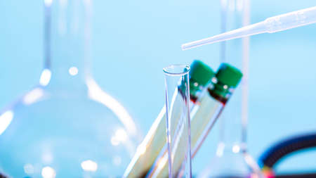 Chemical test tube and pipette close up on blue background.の写真素材