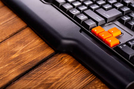 Orange arrow keys on a black keyboard, up, down, left, right buttons on a gaming computer keyboard.の写真素材