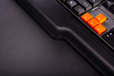 Orange arrow keys on a black keyboard, up, down, left, right buttons on a gaming computer keyboard.の写真素材