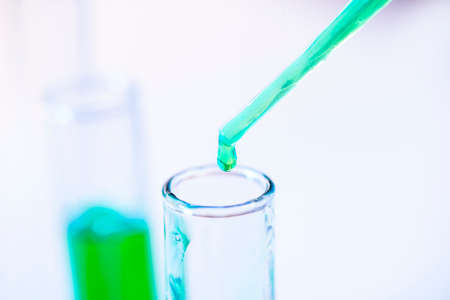 Chemical test tubes and pipette with green liquid close up in a chemical laboratory.の写真素材
