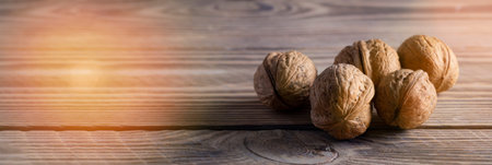 Walnuts on a wooden table close up with place for text, background.