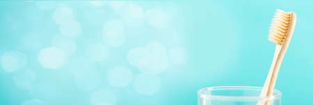 Environmentally friendly natural bamboo toothbrush on blue background. Health care, copy space.の写真素材