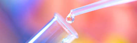 Chemical test tube and pipette with a drop of liquid in a chemical laboratory. A baby is reflected in a drop of liquid. Fertilization concept.の写真素材