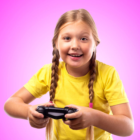 Smiling girl with blond hair plays a computer game on a game console. Black joystick in the hands of...