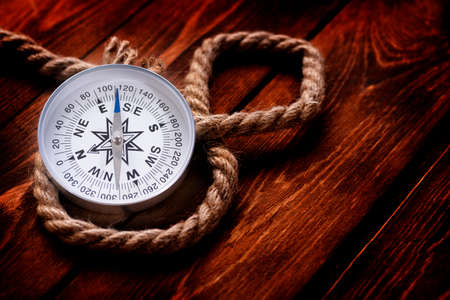 Compass and rope on wooden texture background.の写真素材