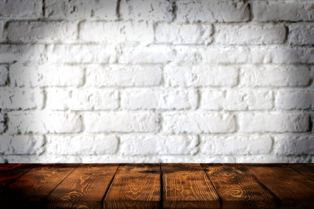 Background wooden table and white brick wall in the background, empty brown wooden table top for...