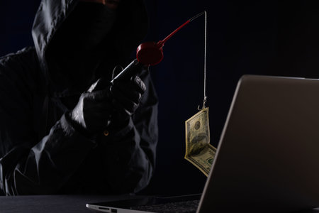 Internet fraud using computer technology, stealing money on the Internet, stealing credit card data. Hacker caught a dollar bill of money on the bait.の写真素材