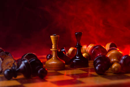 Chess fight, chess pieces on the board, toned in red. Battle fire and smokeの写真素材