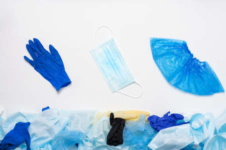 Waste of used personal protective equipment PPE, gloves, disposable masks, shoe covers of medical workers. Garbage contamination after the COVID-19 pandemicの写真素材