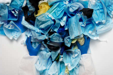 Waste of used personal protective equipment PPE, gloves, disposable masks, shoe covers of medical workers. Garbage contamination after the COVID-19 pandemicの写真素材