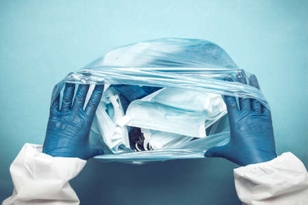 Used medical masks in a plastic bag. Blue face masks after use. Used medical masks.の写真素材