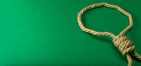 Thick rope tied in a noose on a green felt table, addicted to gamblingの写真素材