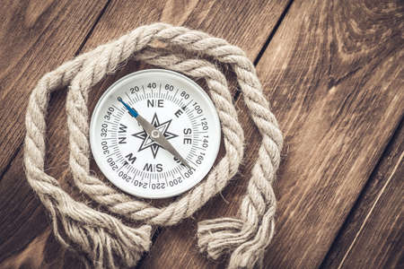 Compass and rope on wooden texture backgroundの写真素材