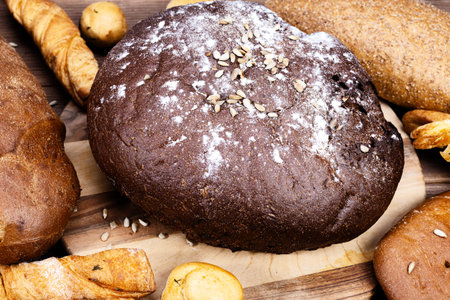 Lots of different breads on a wooden table close up.