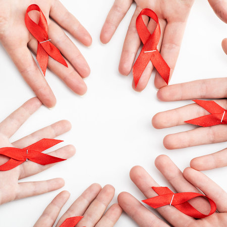 Health care and medicine concept. AIDS awareness. Many people hands are holding red awareness...