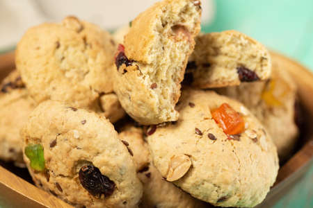 Freshly baked soft oatmeal cookies with raisins, candied fruits, flax and sesame seeds and walnuts close-up.の写真素材