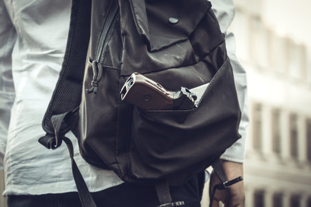 firearms at school. Schoolgirl with a gun in a backpack on a school background. The girl carries a gun to school. school violence.の写真素材