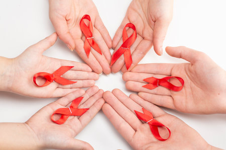 Health care and medicine concept. AIDS awareness. Many people hands are holding red awareness ribbons. International AIDS Day.の写真素材