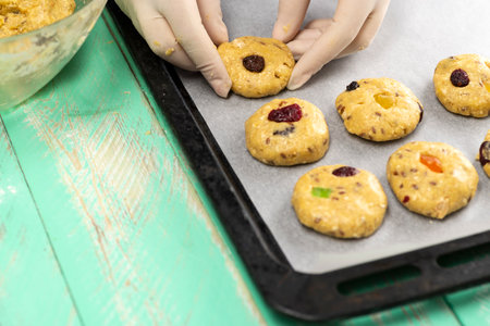 Oatmeal cookies with candied fruits on a baking sheet. Cook preparing oatmeal cookies.の写真素材