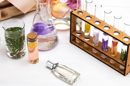 Fresh flowers in chemical test tubes on the table. Preparation of perfumes from natural ingredients, aromatherapyの写真素材