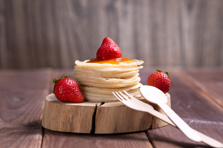 Stack of freshly prepared traditional pancakes with strawberries.の写真素材