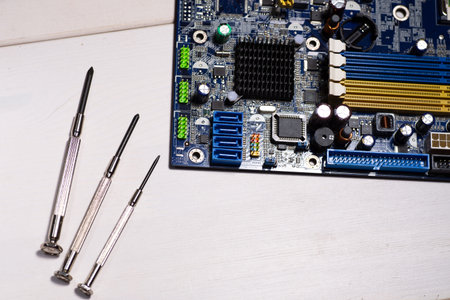 Computer repair. Motherboard repair. Motherboard and repair tools on the mechanic's table.