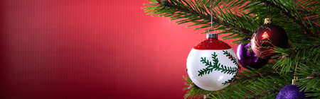 Christmas composition. Balls on a Christmas tree close-up on a red background.