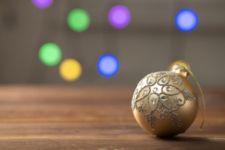 Christmas composition. Golden ball on wooden table on sparkling background.の写真素材