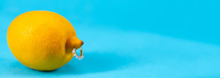Lemon with inserted metal decoration on blue background