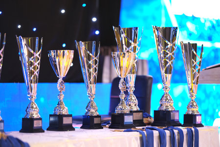 Close-up of golden trophies lined up at a dance event. Collection of trophies. Award cups close upの写真素材