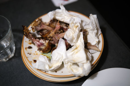 Crumpled used napkins and leftover food standing on a table in a restaurantの写真素材