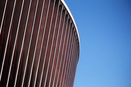 Cladding of a modern sports stadium against a blue skyの写真素材