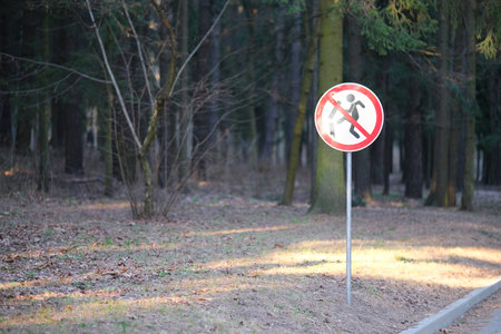 A warning information sign in a red frame in the shape of a triangle in a city parkの写真素材