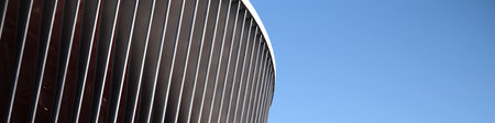 Cladding of a modern sports stadium against a blue skyの写真素材
