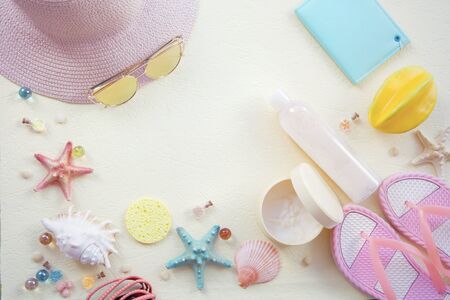 hat slippers notebook and skin cream  out of focus with soft blur on the textured light background yellow background with blurshells top viewの写真素材