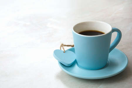 blue cup with black coffee and heart on light blurred table background with empty space for textの写真素材