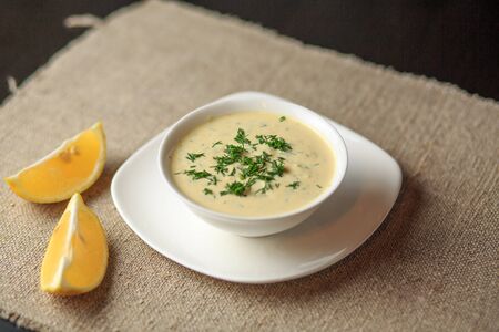 sauce in a plate, mayonnaise in a plate, home-made sauce, sauce Caesar, a lemon, greensの写真素材