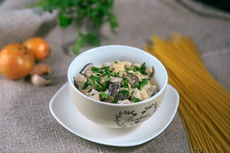 mushrooms of a veshanka and champignons in sauce with macaroni in a white plate on a tableの写真素材