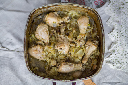 Chicken legs braised with spices and onion in a pan in the oven.の写真素材