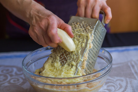 Raw potatoes shredded on a grater. Arms. National Russian dish. Potato pancakes.の写真素材