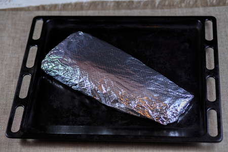Fillet is fresher than fish wrapped in a foil on a black backgroundの写真素材