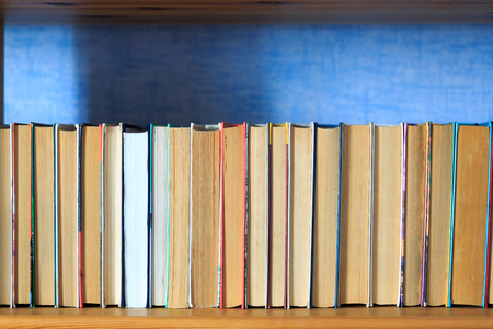 Books on the wooden shelf turned by a cover backの写真素材