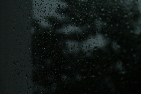 On transparent glass rain drops flow downの写真素材