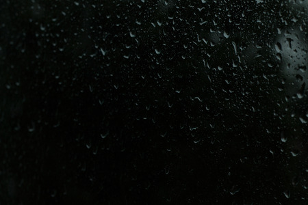 On transparent glass rain drops flow downの写真素材