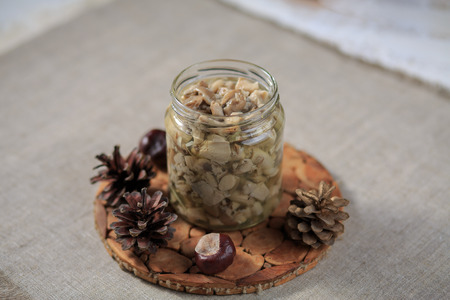 Marinated mushrooms champignons in a steklchnny can on a gray backgroundの写真素材